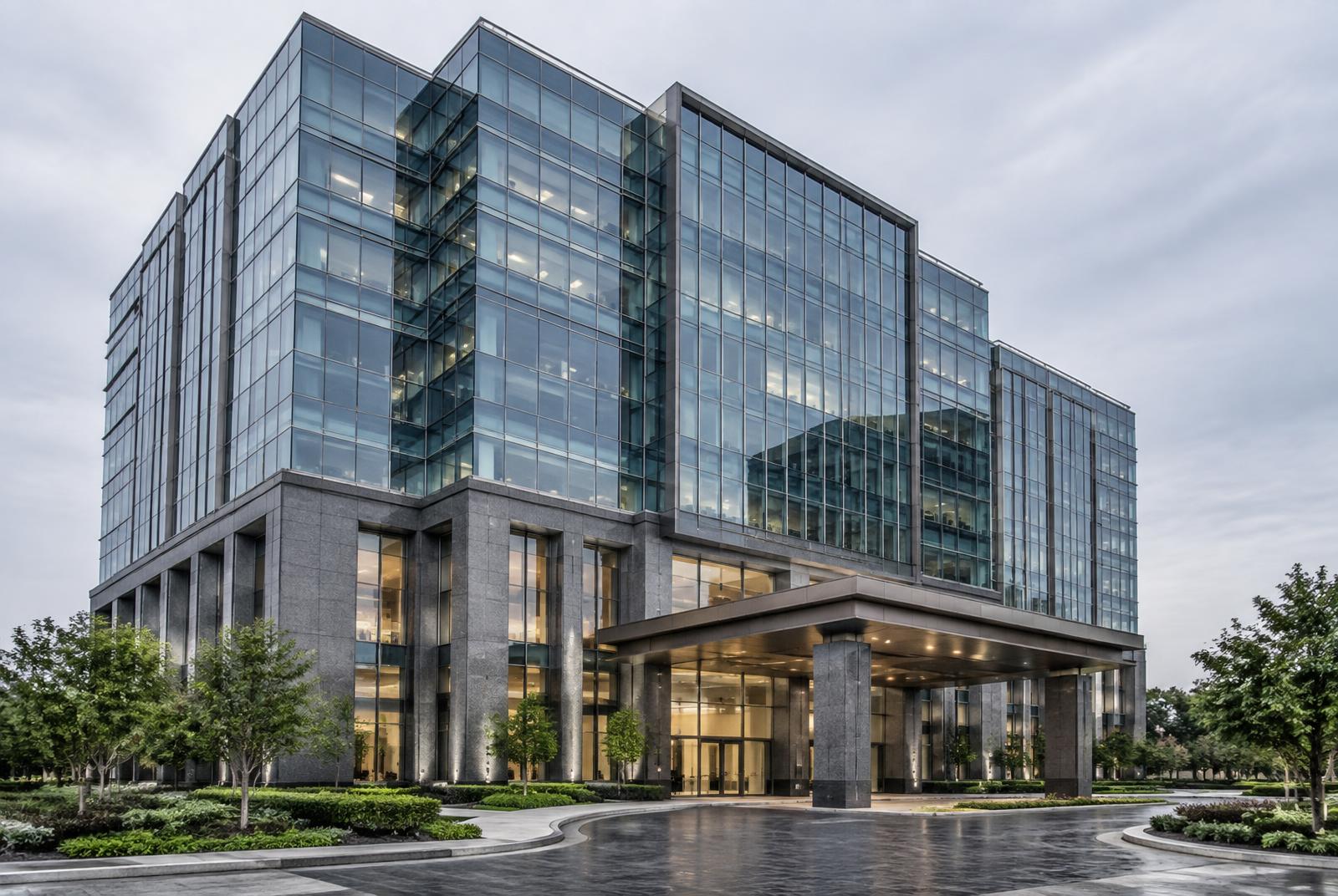 Corporate glass office tower with a formal executive entrance